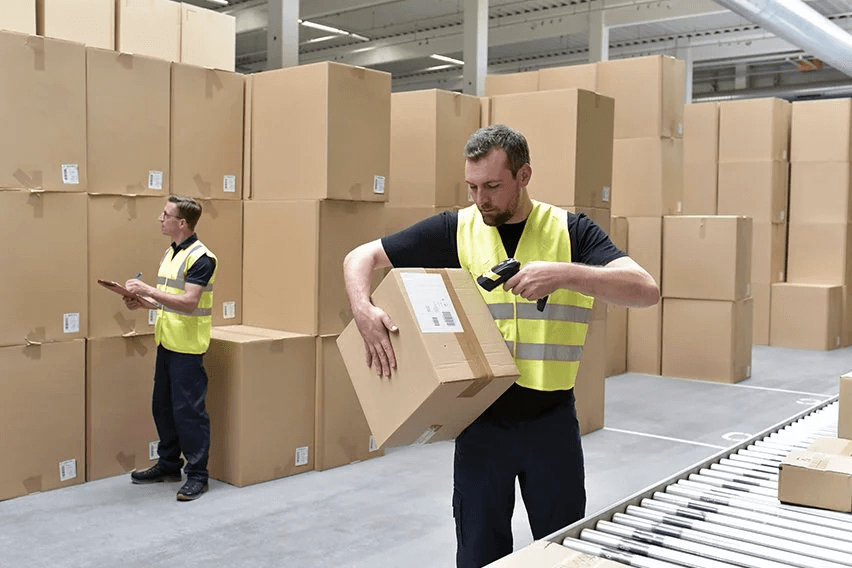 Two warehouse workers with boxes